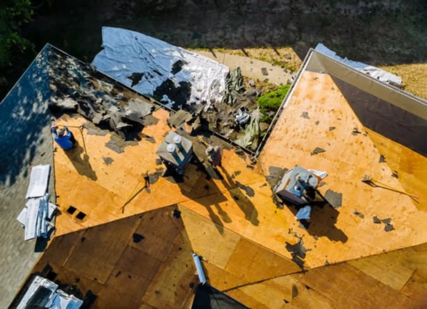 Emergency roofing crew securing a storm-damaged roof with a heavy-duty tarp in Georgia