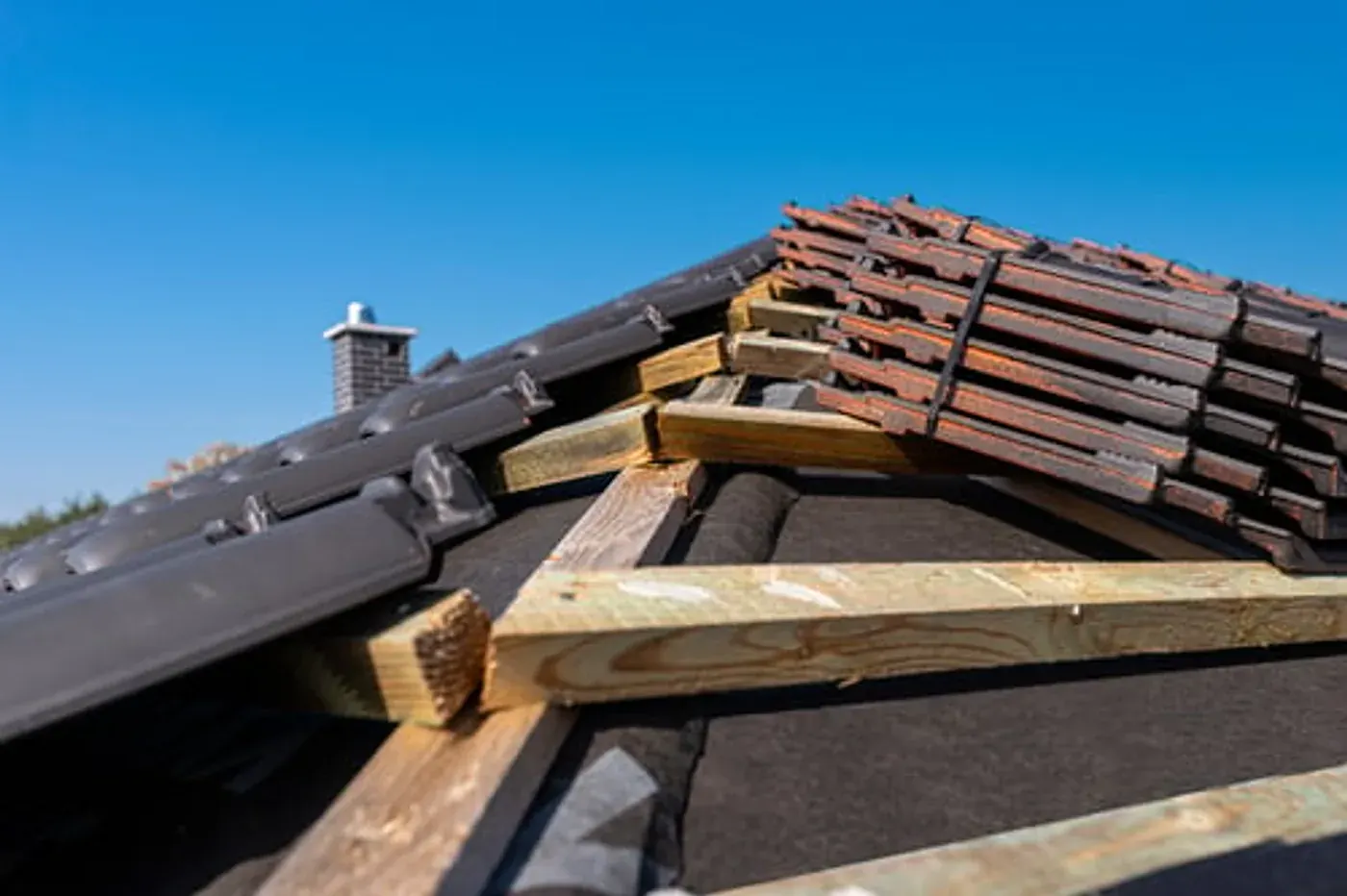 Roofer repairing damaged tiles and flashing on a residential roof in Atlanta, Georgia